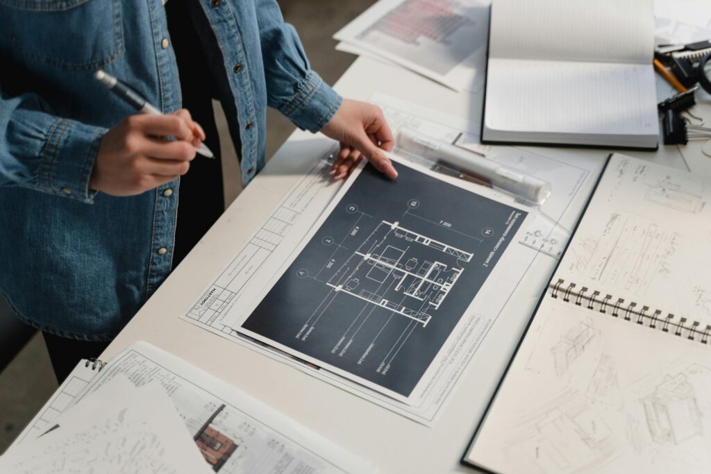 Engineer reviewing architectural blueprints on a desk with technical drawings.